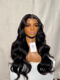 Black wig on a mannequin head with a beige background
