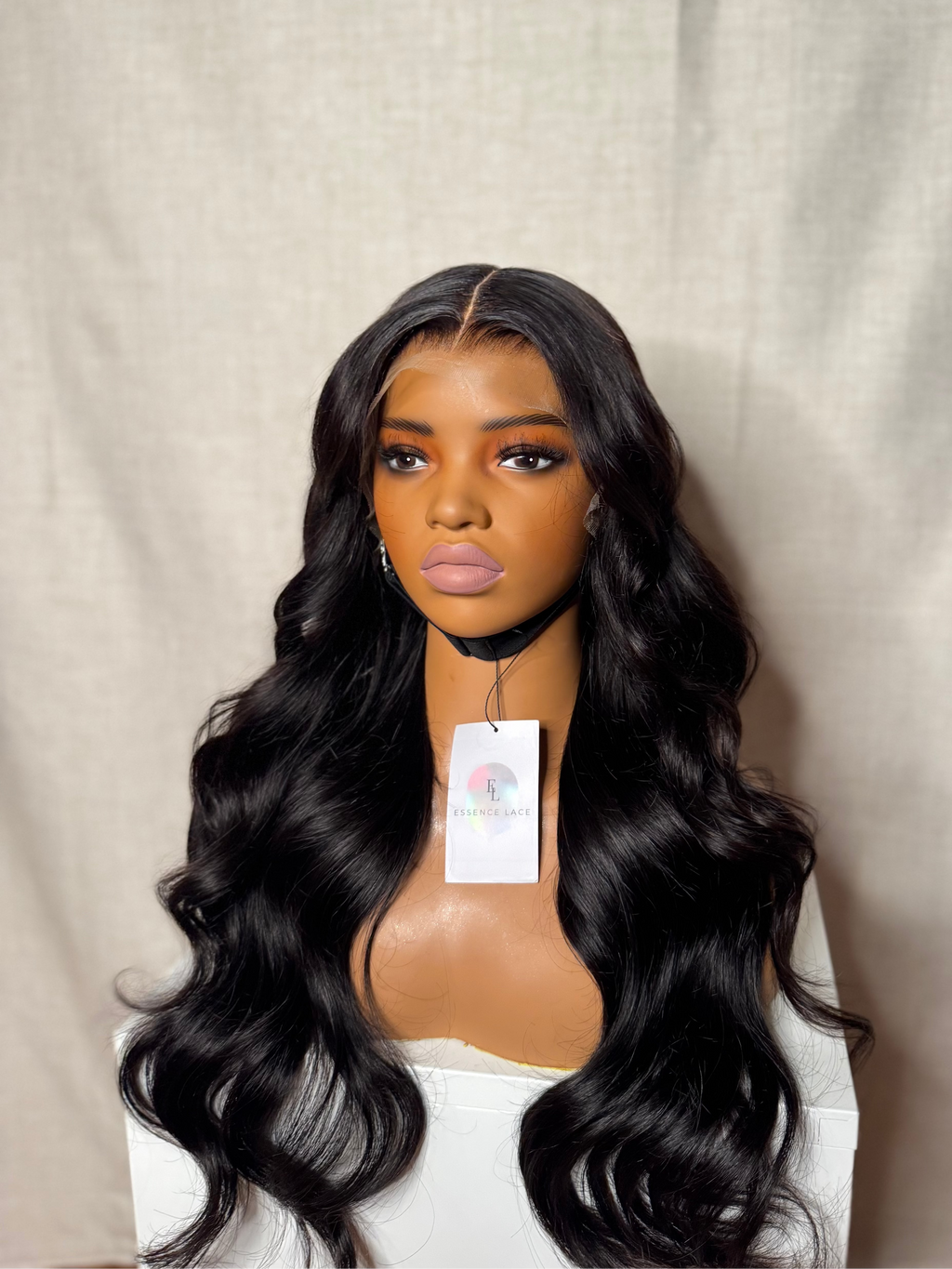Mannequin head with a black wig on a plain background
