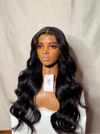 Mannequin head with long black wig on a plain background